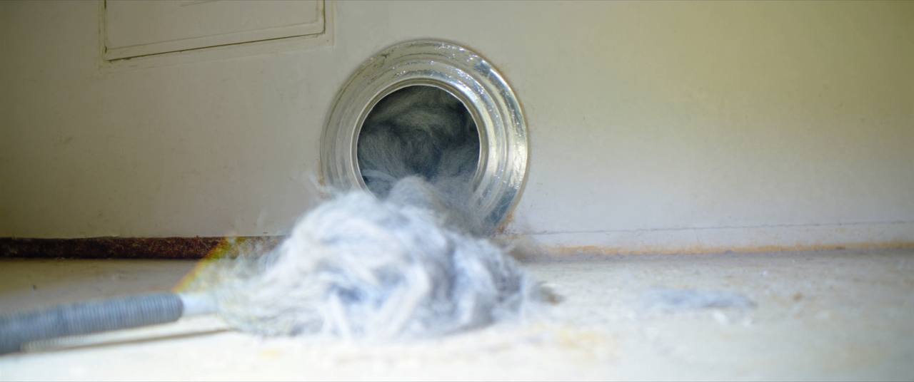 Thick lint buildup being removed from a residential dryer vent duct